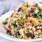 A winter kale and quinoa salad on a white plate.