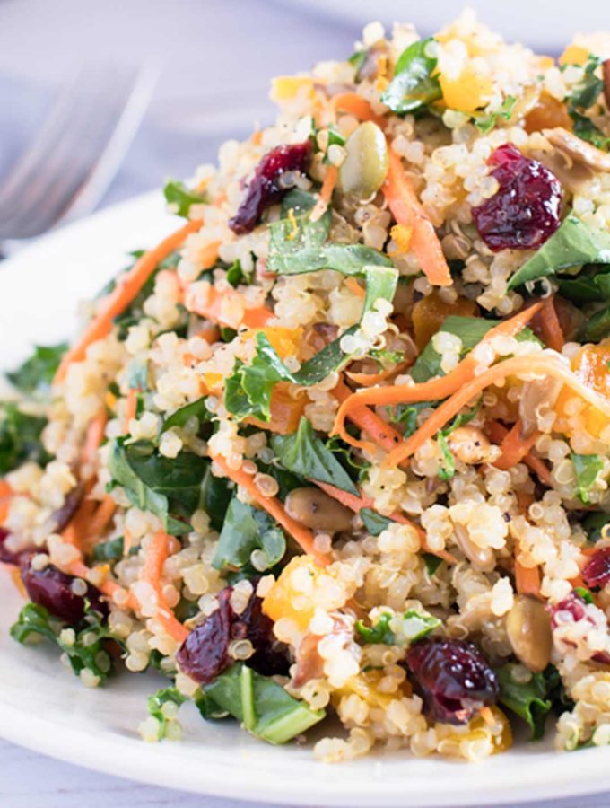 A winter kale and quinoa salad on a white plate.