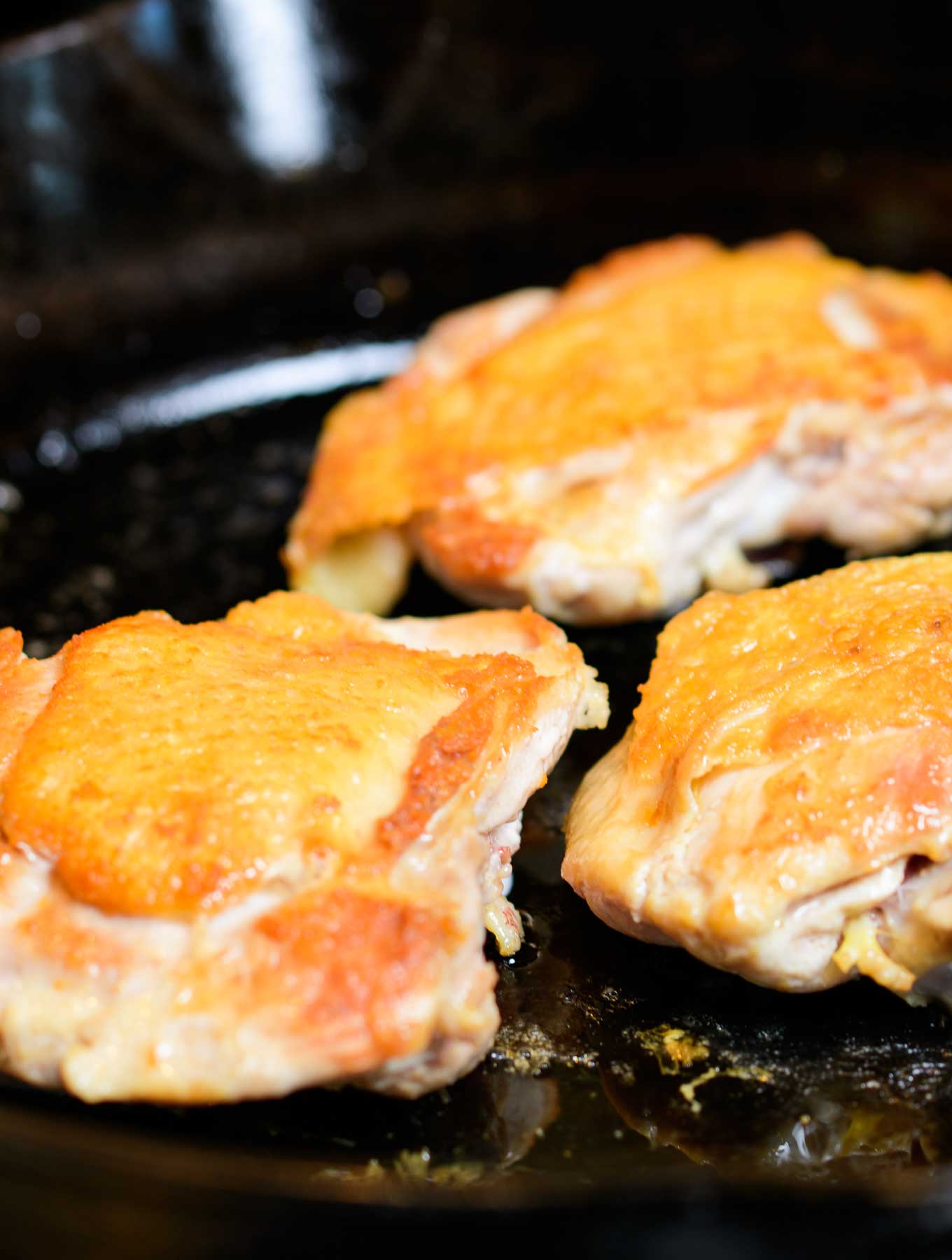 Seared chicken thighs in a cast iron pan