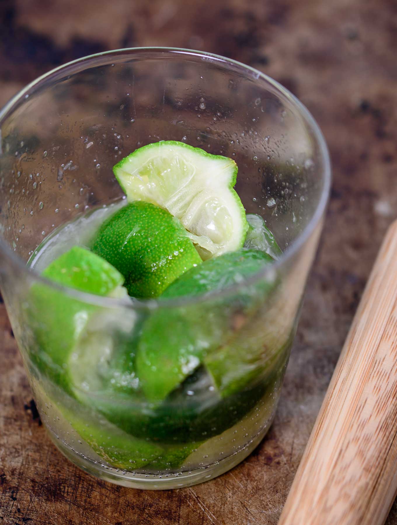 Muddled limes in a glass