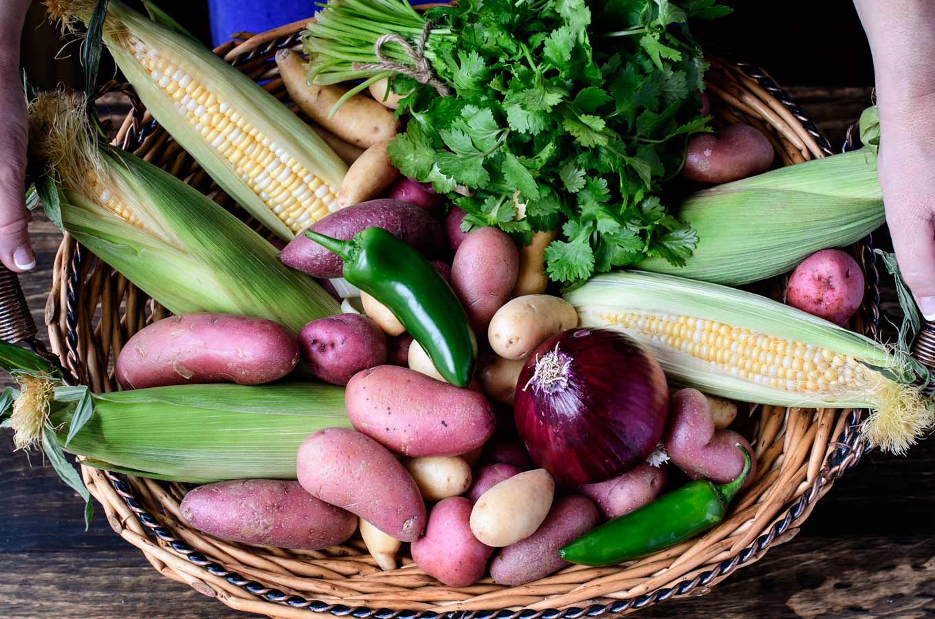 Basket of potatoes, corn, cilantro, red onion and jalapeño