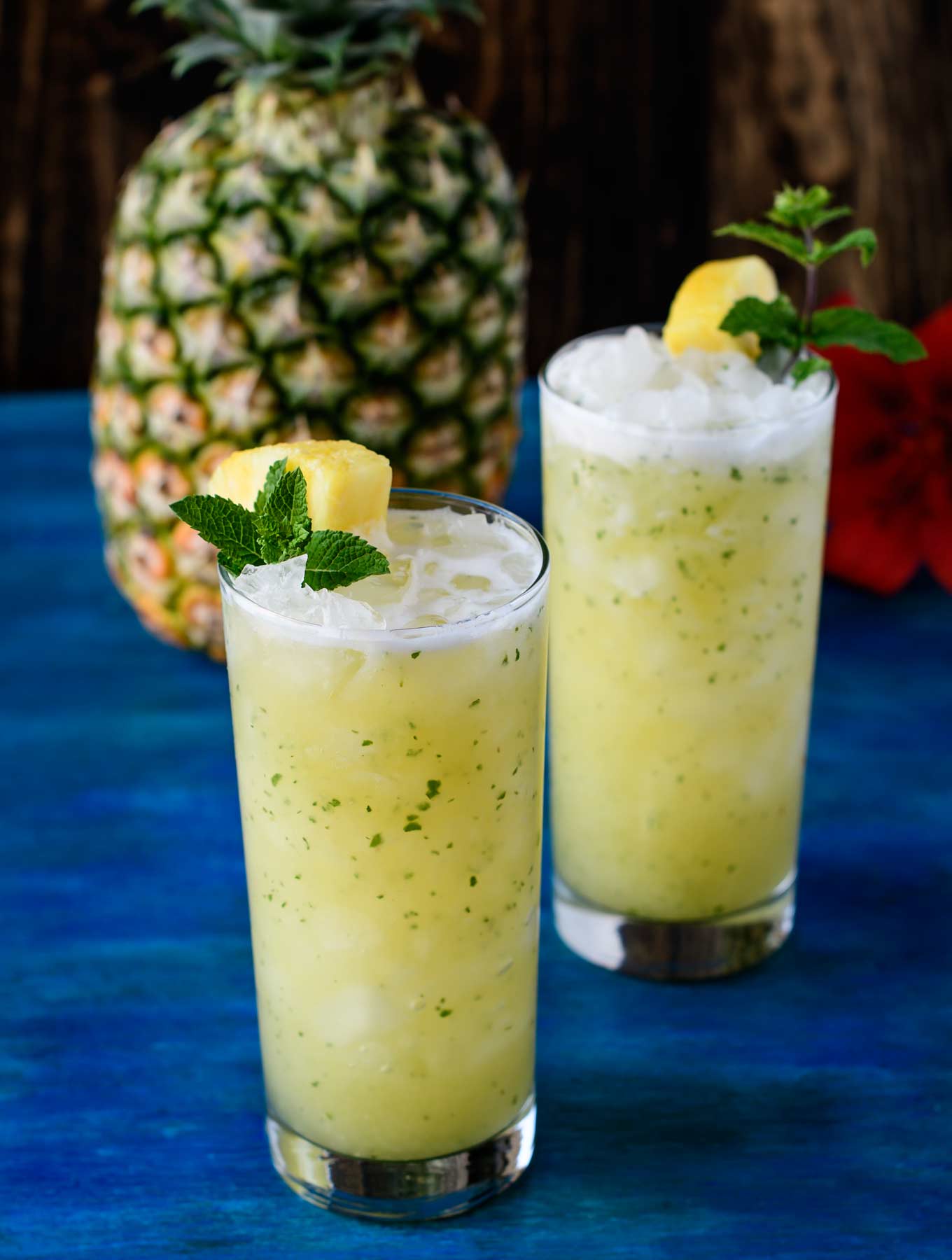 Two pineapple ginger faux-jitos on blue wood board