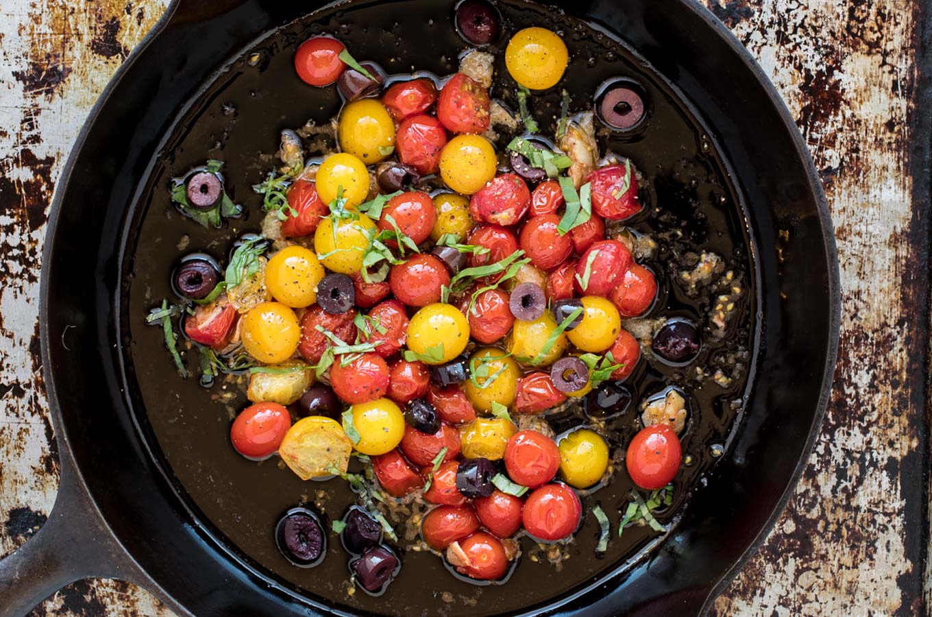Skillet of red and yellow grape tomatoes and olives