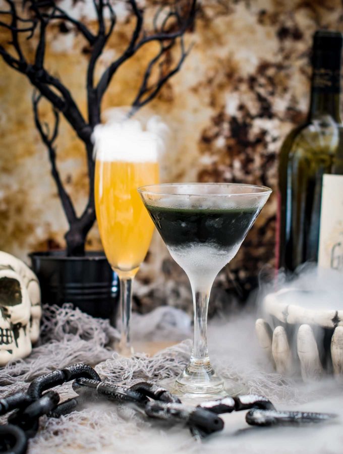 Two halloween cocktails in a spooky scene