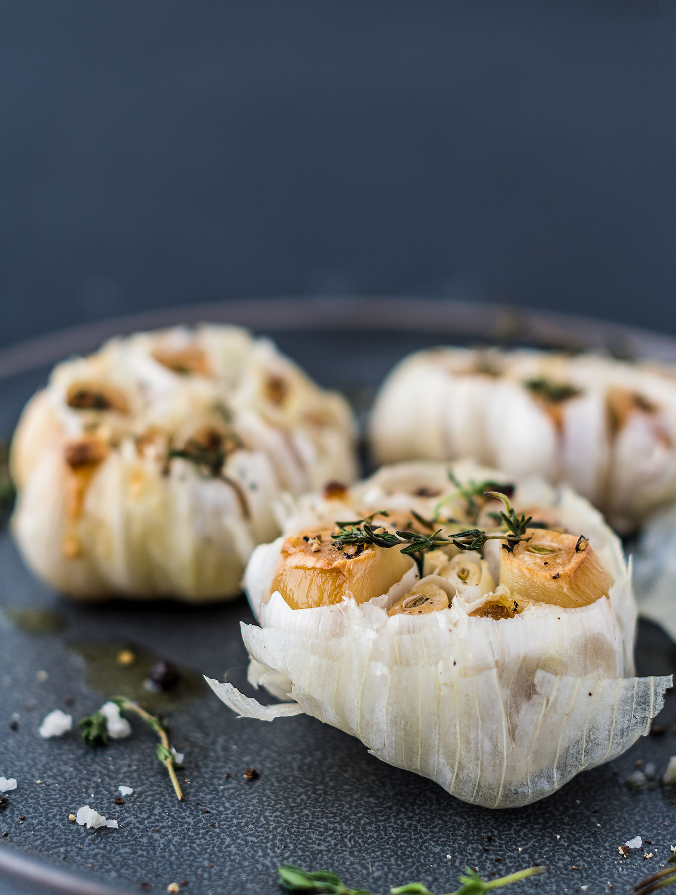 Three bulbs of roasted garlic on a plate