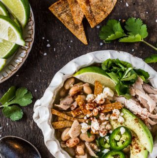 Bowl of green chili chicken soup with toppings