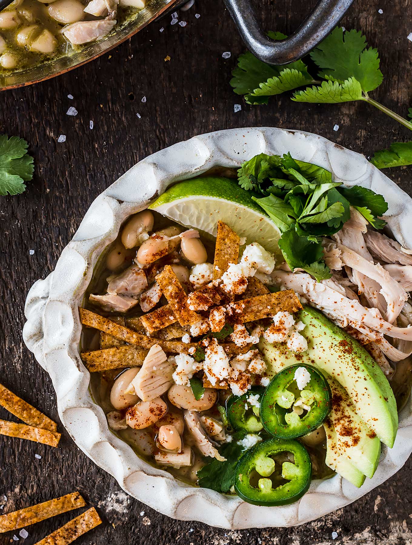 Bowl of green chili chicken soup with toppings