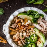 Bowl of green chili chicken soup with toppings