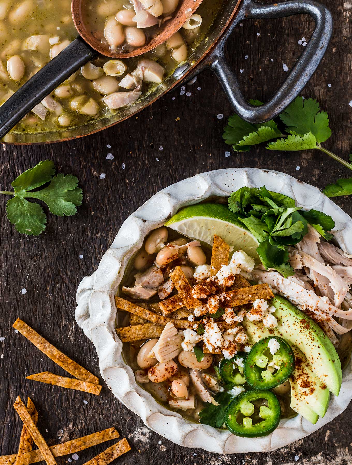 Bowl of green chili chicken soup with toppings