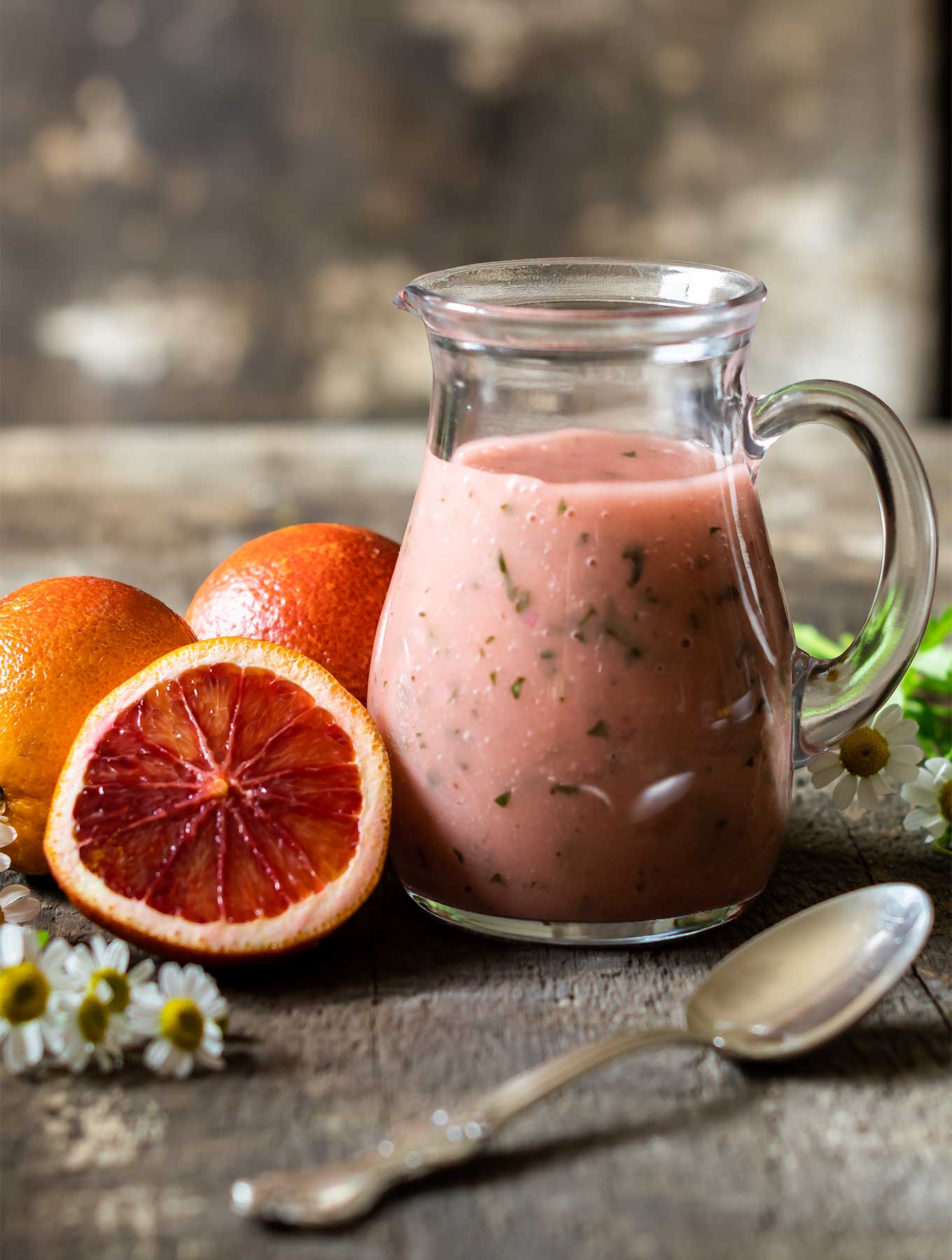 Blood orange vinaigrette with blood oranges on wood