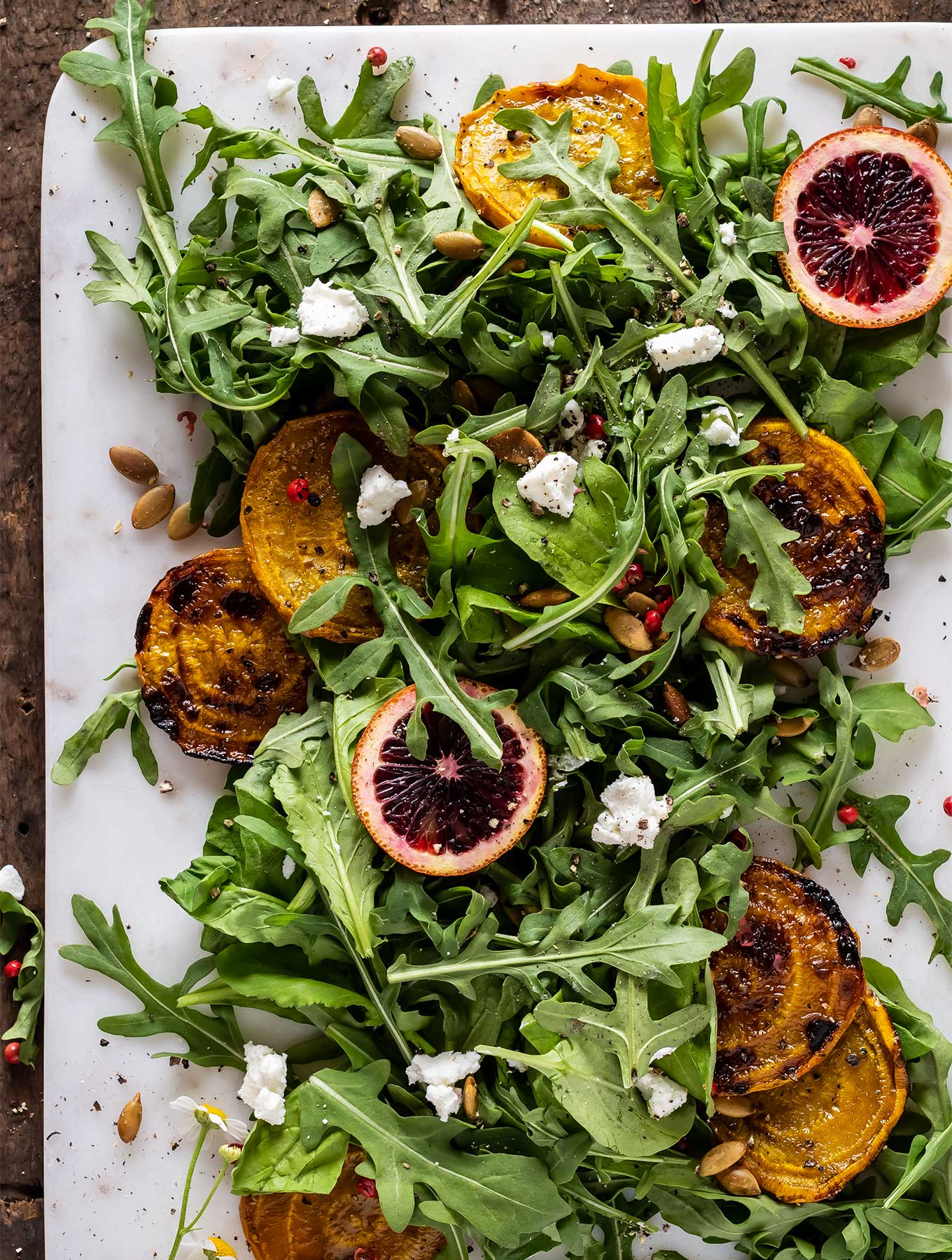 overhead picture of arugula salad with goat cheese and golden beets