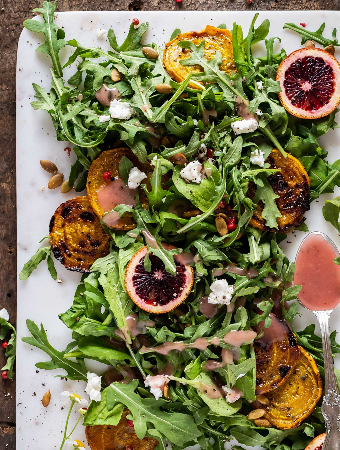 overhead picture of arugula salad with goat cheese and golden beets