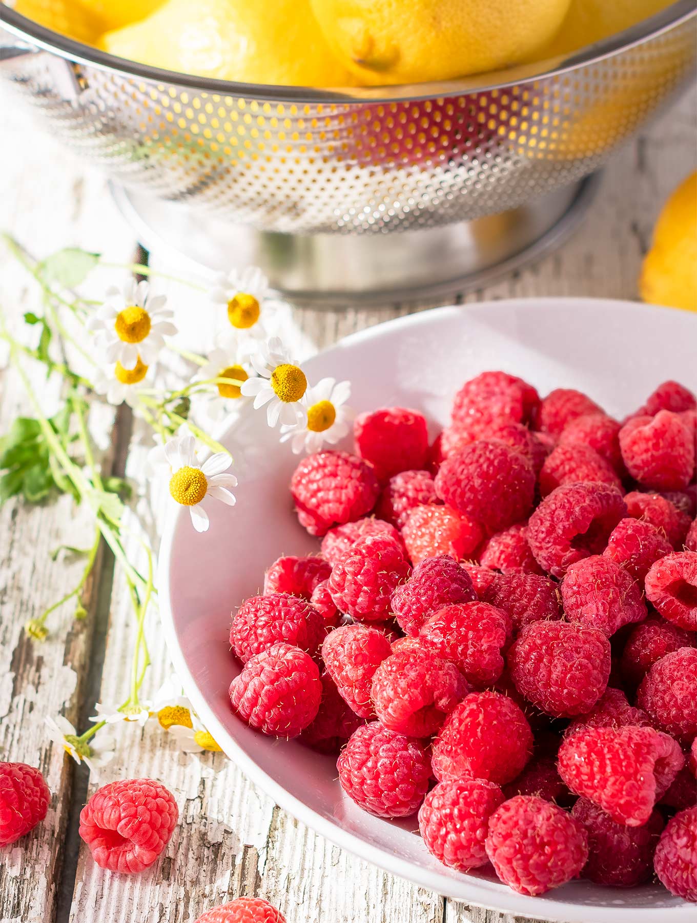 Bowl of fresh raspberries and lemons