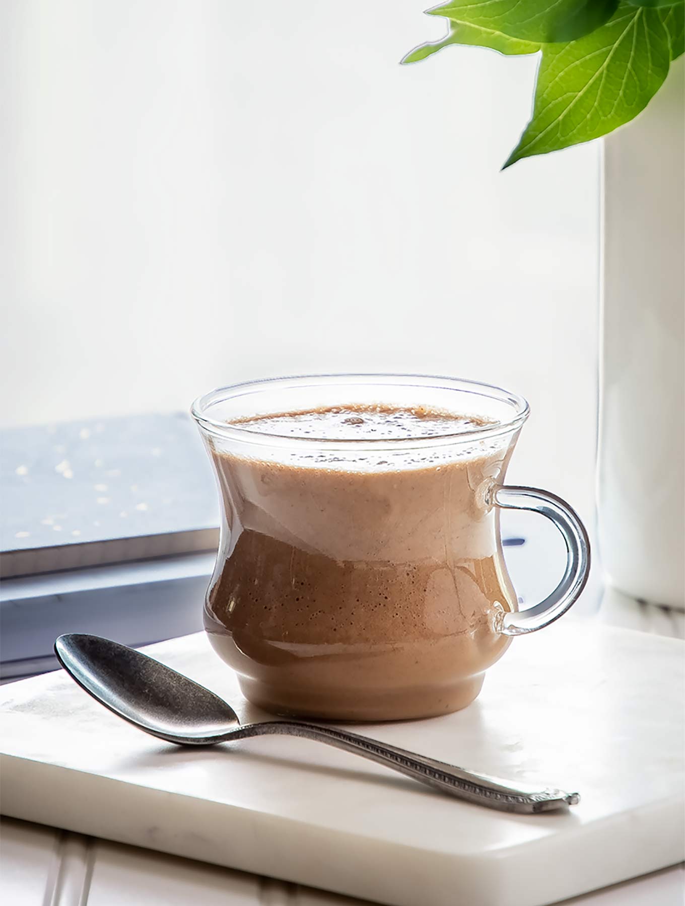 close up of clear mug of cardamom cashew latte