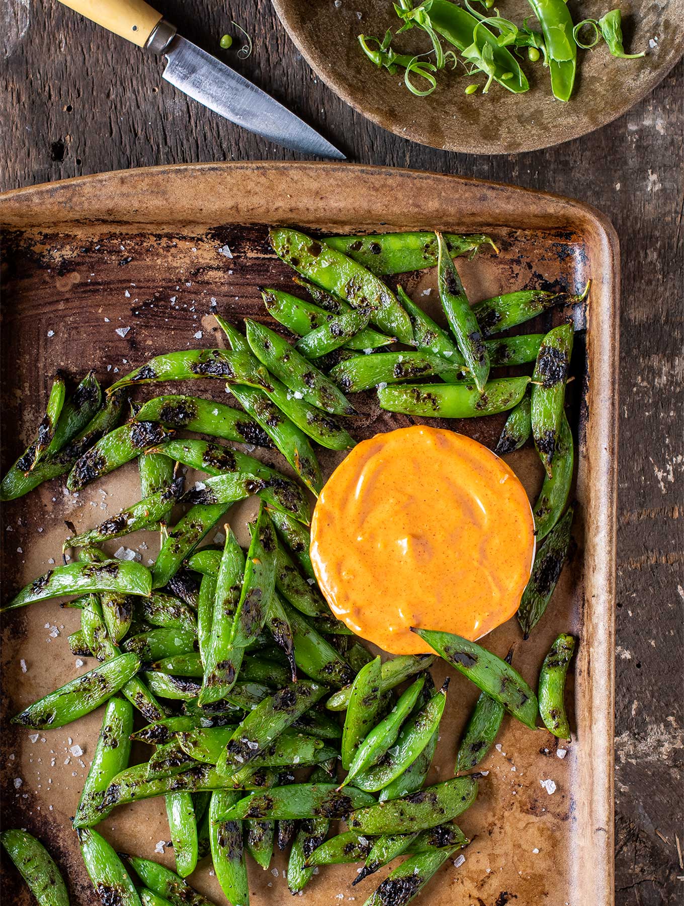 Tray of grilled snap peas with smoked paprika aioli