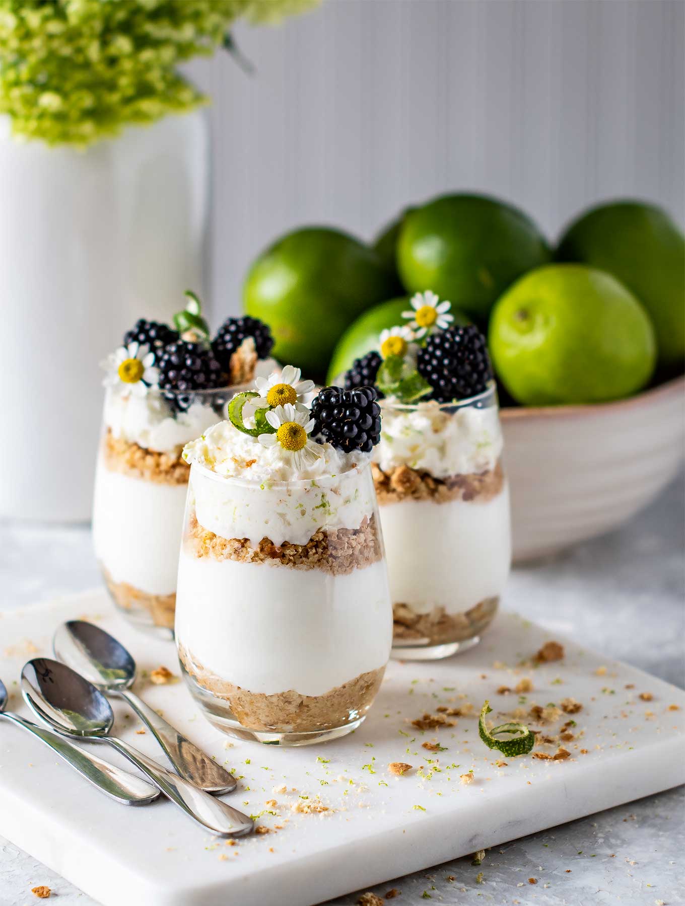 Three glasses of key lime pie parfaits on a marble square