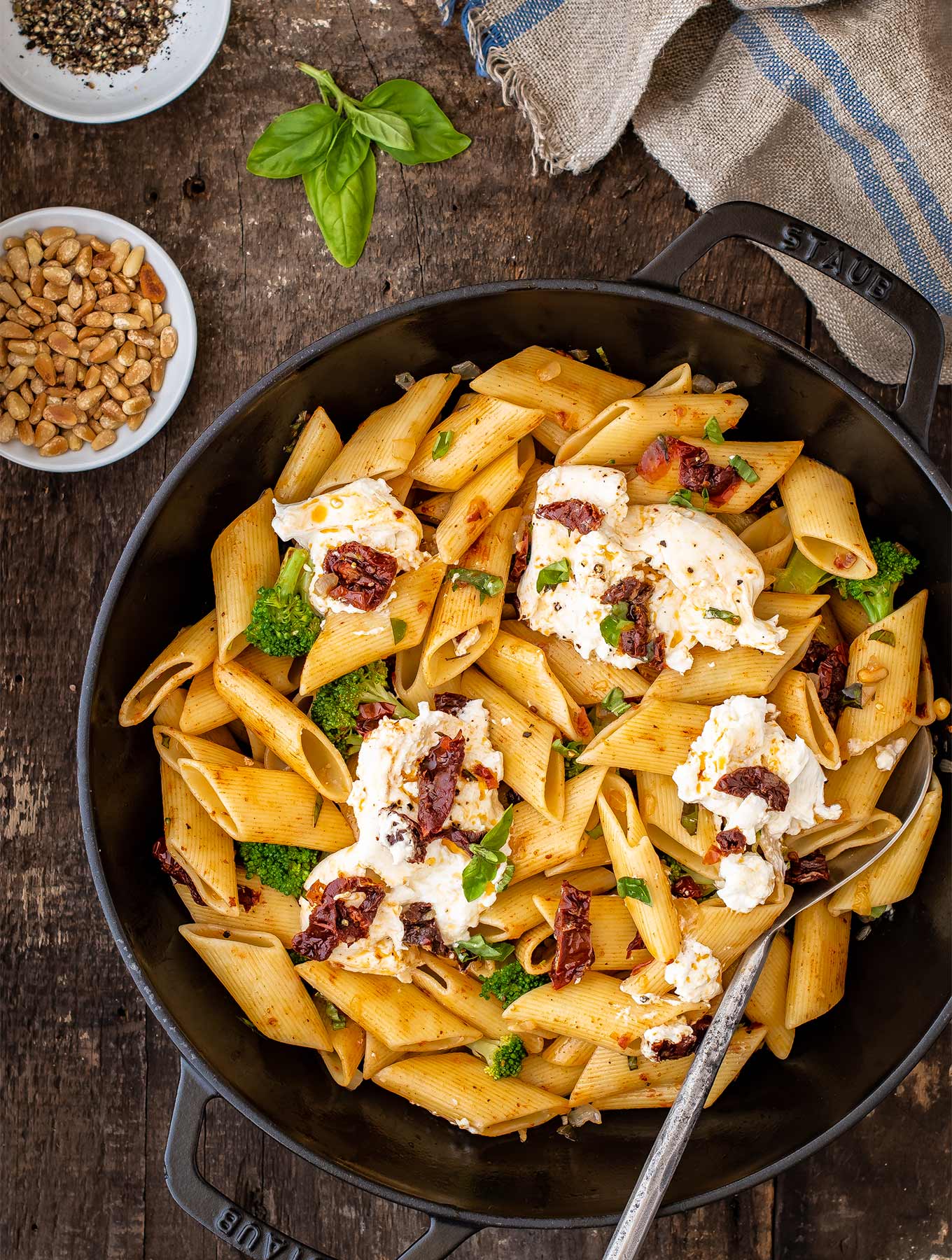 Skillet of pasta with sun dried tomatoes, broccoli and burrata